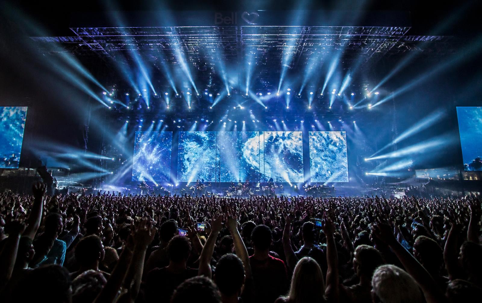 Arena concert crowd with stage lighting beams